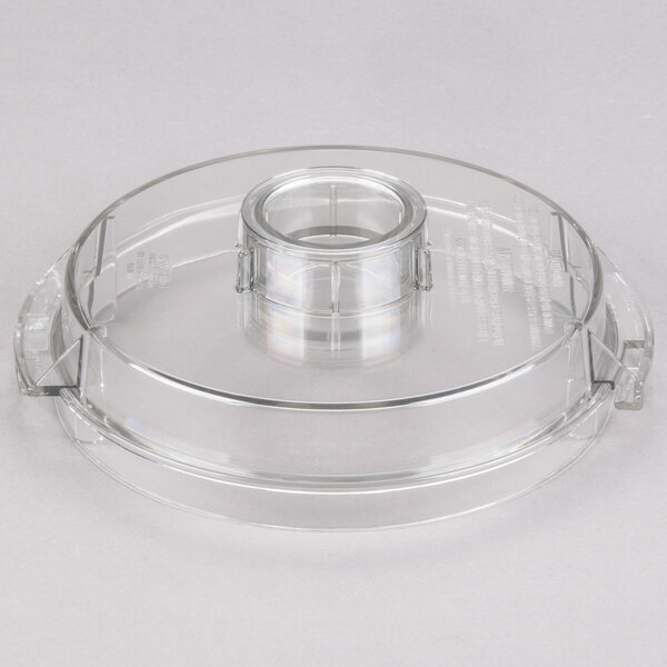 A clear plastic Waring flat bowl cover with a circular hole.