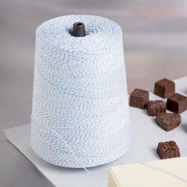 A blue and white spool of Baker's Mark Baker's twine on a white background.