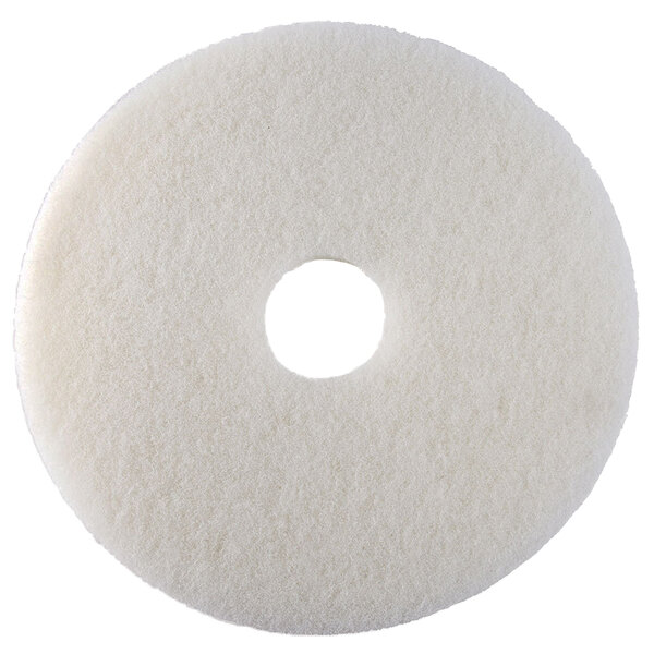 A white circular Scrubble floor pad with a hole in the middle.