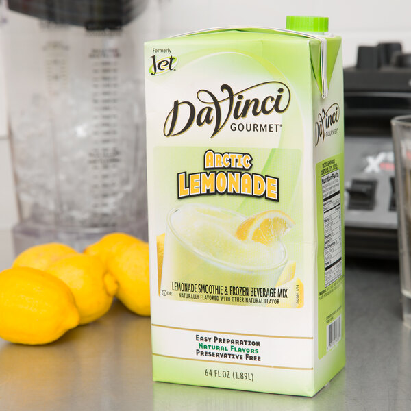 A bottle of DaVinci Gourmet Arctic Lemonade Smoothie Mix on a counter next to lemons.