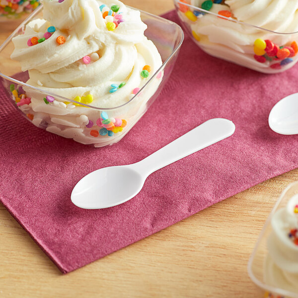 A bowl of ice cream with sprinkles and a white spoon.