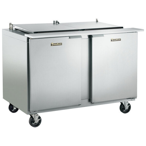 A Traulsen stainless steel refrigerated sandwich prep table with two doors on wheels.