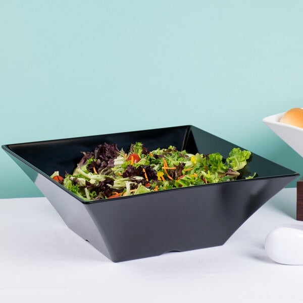 A black square Tablecraft melamine bowl with salad inside.