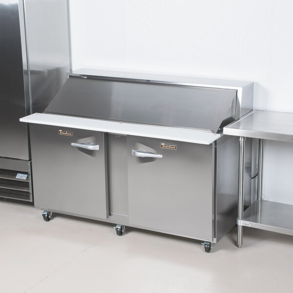 A Traulsen stainless steel refrigerated sandwich prep table with left and right hinged doors on a counter.