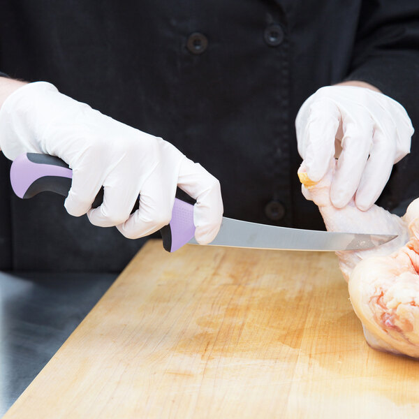A person in white gloves using a Mercer Culinary purple boning knife to cut chicken.