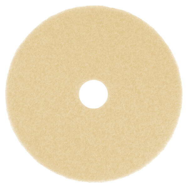 A beige circular Scrubble burnishing floor pad with a hole in the middle.