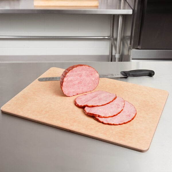 A San Jamar Tuff-Cut cutting board with sliced ham on it.