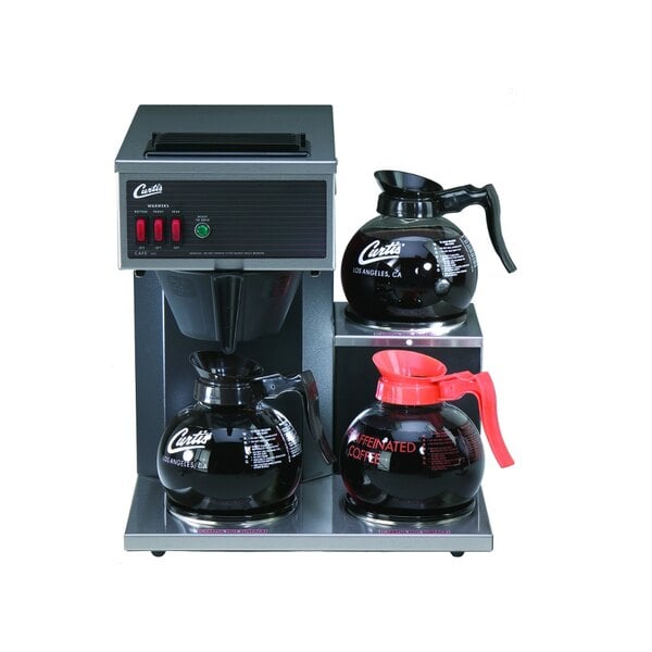 A Curtis commercial pourover coffee maker with several black coffee pots on top.