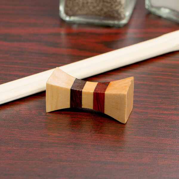 A wood chopstick rest with three lines.