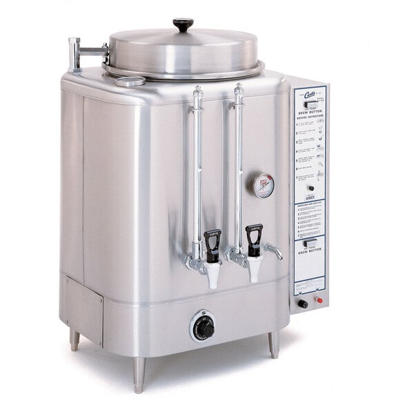 A large stainless steel Curtis coffee urn with two lids.