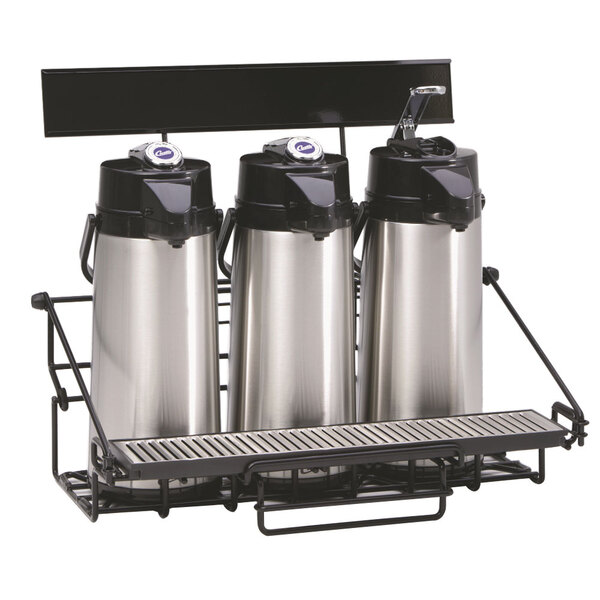 A black rectangular wire rack holding three stainless steel Curtis coffee airpots.
