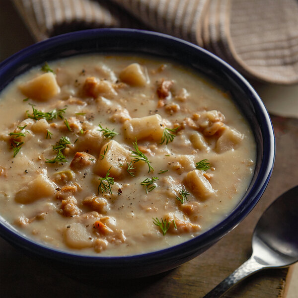 A bowl of Chincoteague New England clam chowder with a spoon.