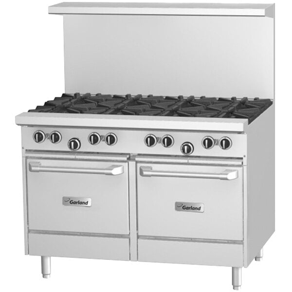 A large white Garland commercial gas range with a griddle, convection oven, and storage base, with black knobs.