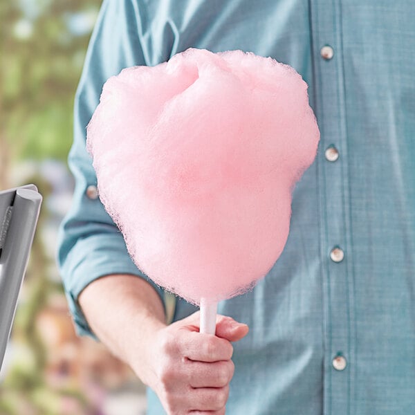 A man holding a pink cotton candy made with Great Western Pink Vanilla Cotton Candy Floss Sugar.