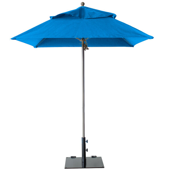 A Grosfillex Pacific Blue fiberglass umbrella on a metal stand.