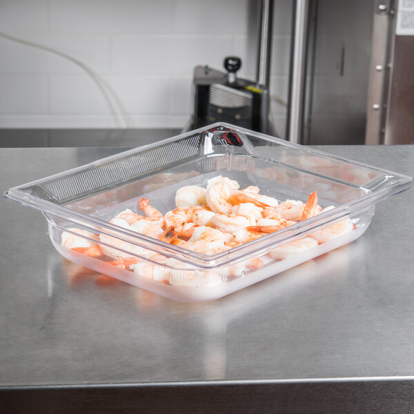 A clear Vollrath polycarbonate food pan with shrimp in it on a counter.