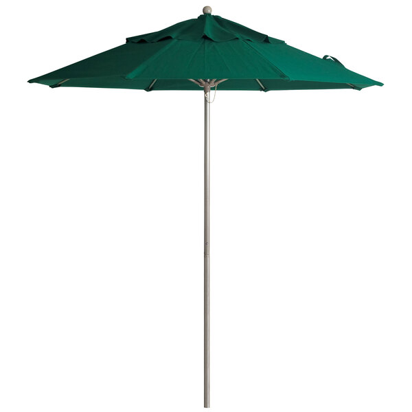 A Grosfillex forest green umbrella on a metal pole.