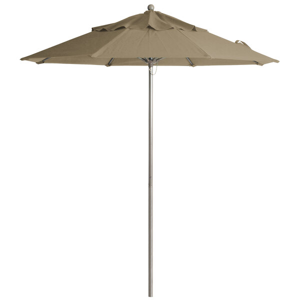 A taupe Grosfillex Windmaster umbrella on a pole.