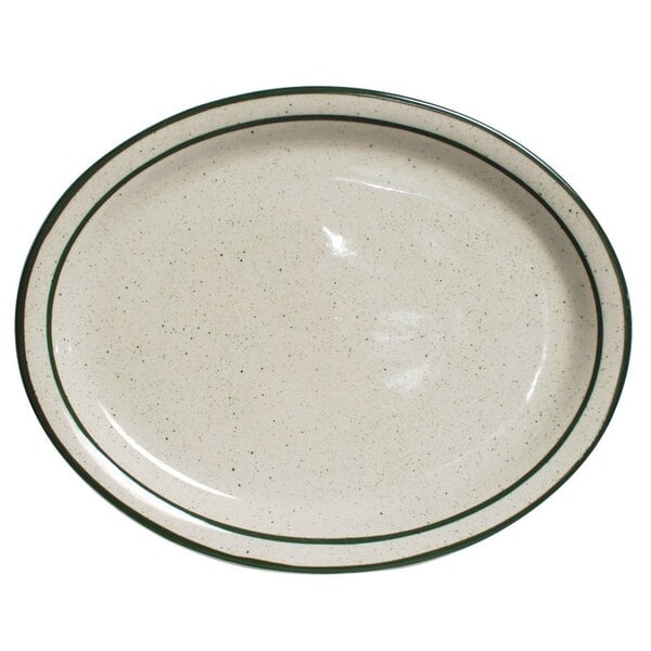 A white narrow rim oval china platter with green speckled rim.