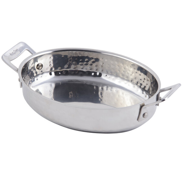 A Bon Chef stainless steel oval au gratin pan with hammered finish and handles.