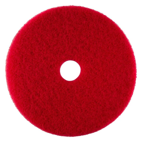 A red circular Scrubble buffing pad with a hole in the middle.