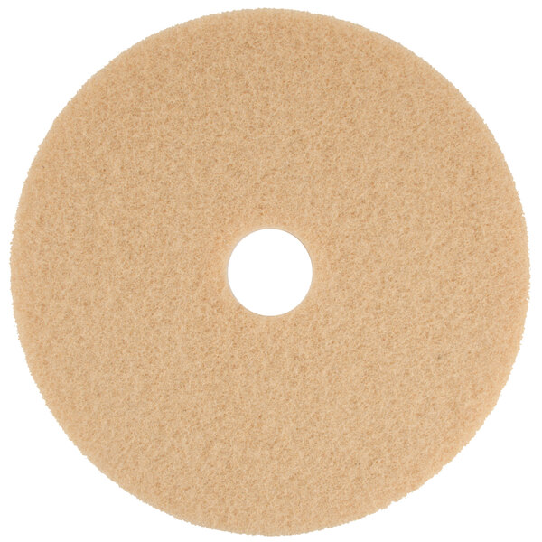 A tan circular floor pad with a white center hole.