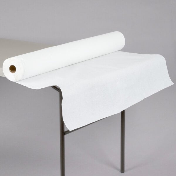 A white roll of embossed paper table cover on a table.