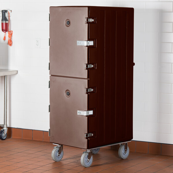 A brown metal Cambro double compartment tray and sheet pan carrier with silver hinges.