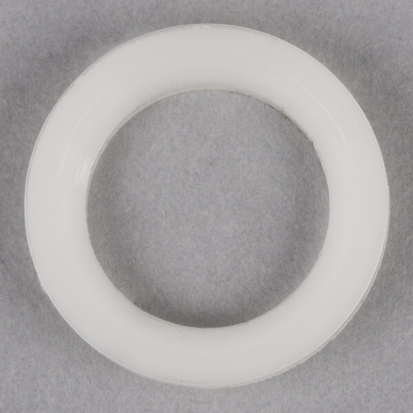 A white plastic ring on a grey surface.