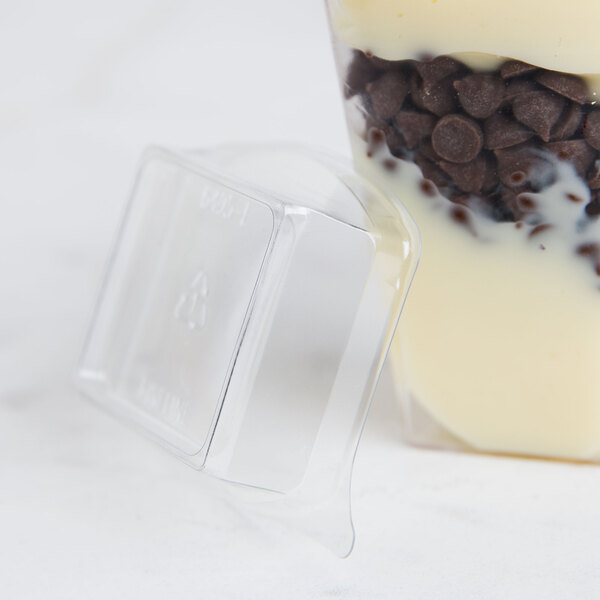 A plastic container with a Fineline clear dome lid filled with chocolate chips.