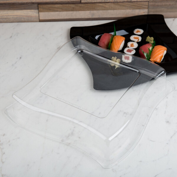 A clear dome lid on a plate of sushi.