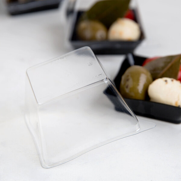 A Fineline clear plastic container with a clear plastic dome lid holding green olives.