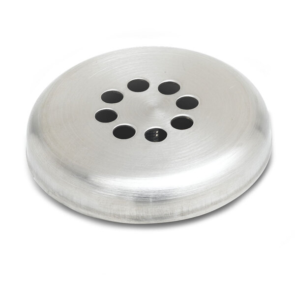 A silver circular overflow waste valve with a rotary strainer inside and holes in the surface.