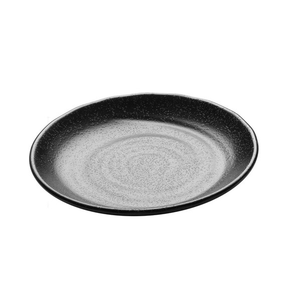 A black round plate with a white speckled surface.