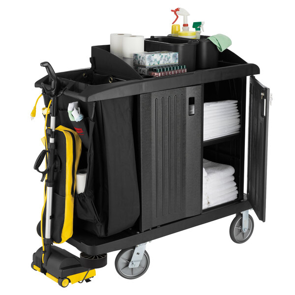 A black Rubbermaid housekeeping cart full of cleaning supplies.
