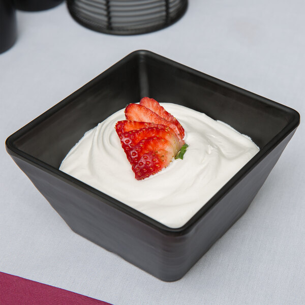 An American Metalcraft black faux slate melamine bowl filled with yogurt and strawberries.