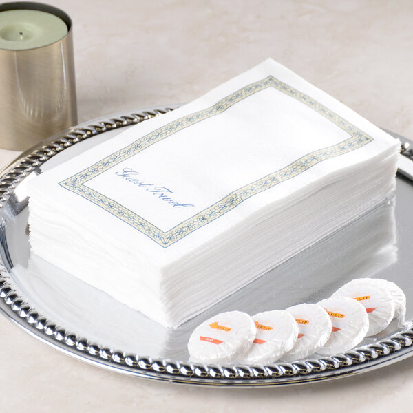 A silver tray holding a stack of white Hoffmaster Regal linen-like paper guest towels.