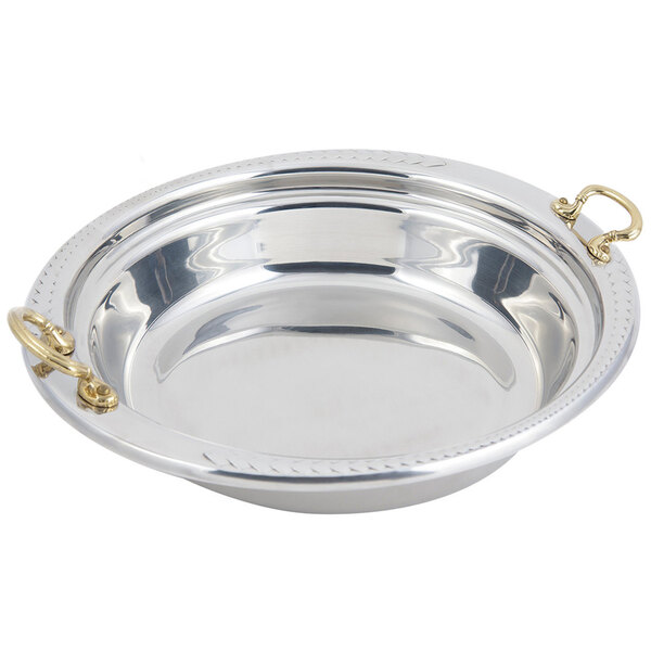 A stainless steel Bon Chef casserole food pan with laurel design and round brass handles.