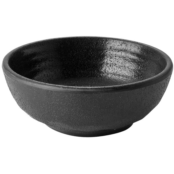 A black round melamine sauce cup with a white background.