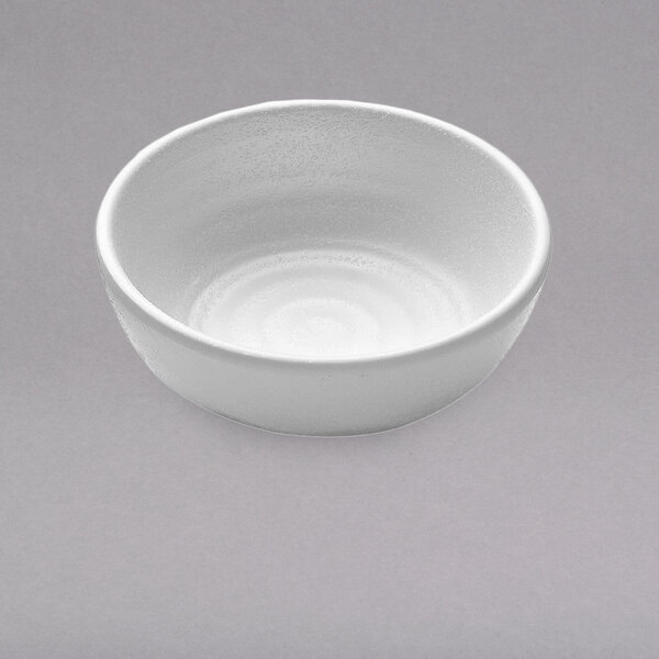 A white Elite Global Solutions round sauce cup on a gray background.