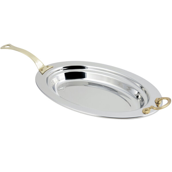 A silver Bon Chef oval food pan with a long brass handle.
