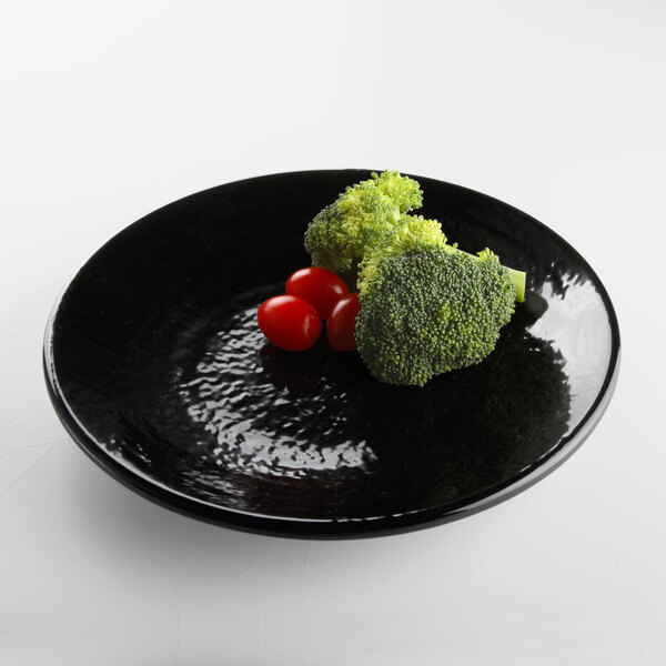 An Elite Global Solutions black melamine plate with broccoli and cherry tomatoes on it.