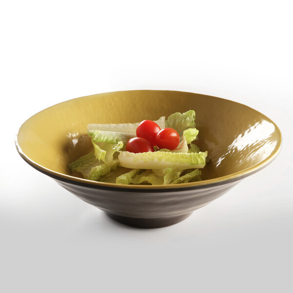 An Elite Global Solutions olive oil-colored melamine bowl filled with salad and tomatoes.