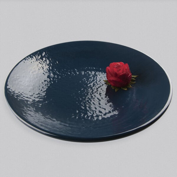 A red rose on a lapis-colored Elite Global Solutions round plate.