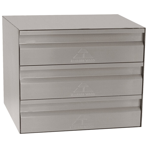 A stainless steel metal box with three drawers on a table.