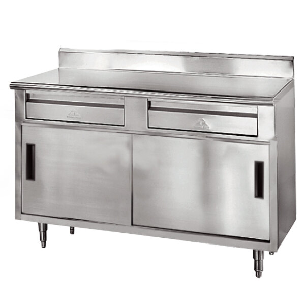 A stainless steel Advance Tabco commercial work table with an enclosed base, two drawers, and two sliding doors.