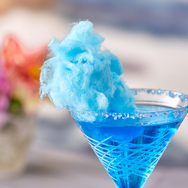 A blue drink with a Great Western Blue Raspberry Cotton Candy cloud on the rim.