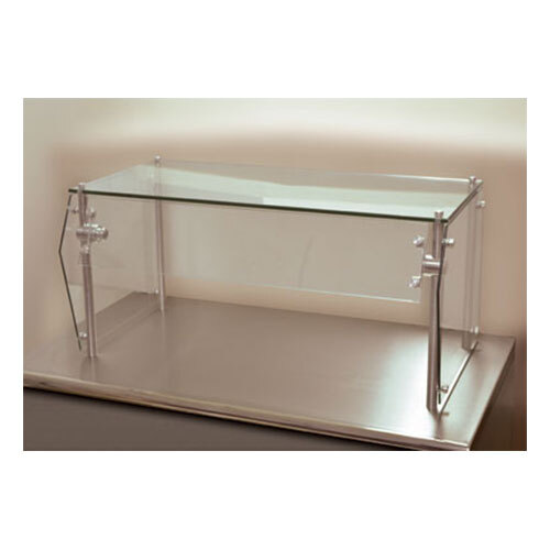 A clear glass food shield with a metal frame over a white surface.