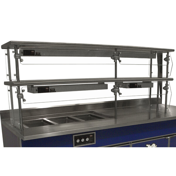 A stainless steel double tier self service food shield on a counter.