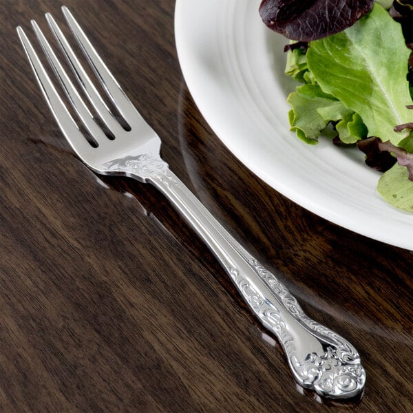 Oneida Rosewood stainless steel fork next to a plate of salad.